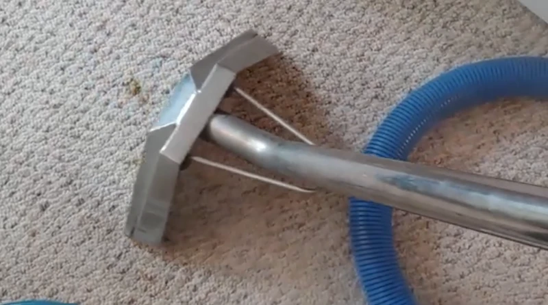 Close up of a cleaning wand on a beige carpet